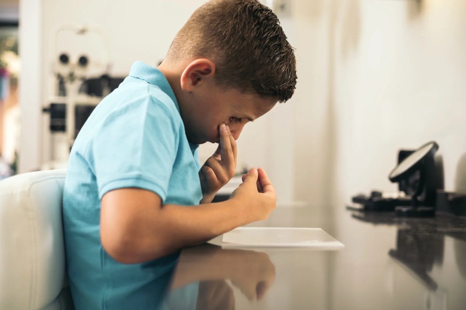 A young patient holding a contact lens on their fingertip